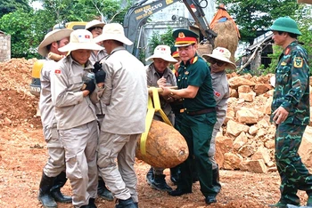 Các lực lượng phối hợp di dời, xử lý quả bom còn sót lại sau chiến tranh. (Ảnh: LA)