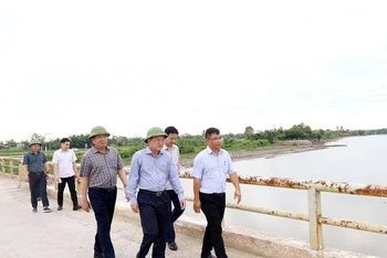 Phó Chủ tịch tỉnh Quảng Bình Phan Phong Phú (đội mũ đi giữa) cùng lãnh đạo các ngành kiểm tra hiện trạng cầu sông Thai. (Ảnh: VM)