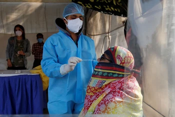 Nhân viên y tế lấy mẫu xét nghiệm Covid-19 cho người dân tại Ahmedabad, Ấn Độ. (Ảnh: Reuters)