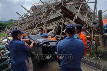 Nhân viên cứu hộ chuyển nạn nhân ra khỏi ngôi nhà bị sập trong trận động đất ở La Trinidad, tỉnh Benguet, Philippines, ngày 27/7/2022. (Ảnh: AFP/TTXVN)