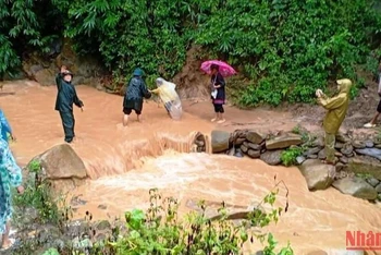 Bộ đội Biên phòng đồn Tam Chung ở huyện Mường Lát trợ giúp, di chuyển hộ dân sinh sống ở khu vực nguy hiểm đến nơi an toàn.