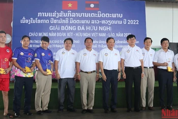 Bộ trưởng Giáo dục và Thể thao Lào Phouth Simmalavong và Đại sứ Nguyễn Bá Hùng chụp ảnh lưu niệm với đại diện các đội bóng. (Ảnh: TRỊNH DŨNG)