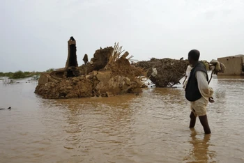 Một người dân lội qua khu vực bị ngập lụt ở Kassala, Sudan, ngày 18/8/2022. (Ảnh: AFP)