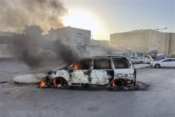Ô-tô bị đốt cháy trong các vụ đụng độ tại Tripoli, Libya, ngày 27/8/2022. (Ảnh: THX/TTXVN)