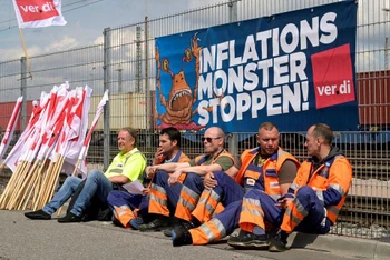 Các công nhân tại cảng container Burchardkai ở Hamburg, Đức đình công và yêu cầu tăng lương, với biểu ngữ “Hãy ngăn chặn “con quái vật” lạm phát” phía sau, ngày 9/6/2022. (Ảnh: Reuters)