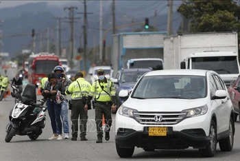 Cảnh sát kiểm tra các phương tiện sau vụ tấn công vào đồn cảnh sát ở Bogota, Colombia, ngày 28/3/2022. (Ảnh tư liệu: AFP/TTXVN)