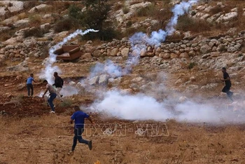 Người biểu tình Palestine ném hơi cay về phía binh lính Israel tại Nablus, Khu Bờ Tây, ngày 23/9/2022. (Ảnh: THX/TTXVN)