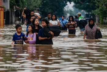 Sơ tán người dân khỏi khu vực ngập lụt tại Indonesia. (Ảnh: AFP/TTXVN)