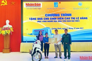 Đại diện Báo Nhân Dân và các đại biểu trao tặng xe máy, máy tính cho sinh viên Cao Thị Lệ Hằng.