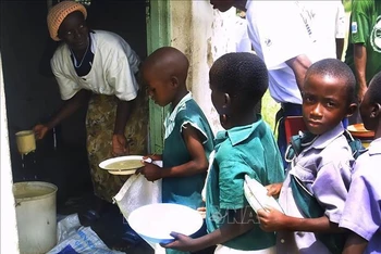 Trẻ em chờ nhận khẩu phần ăn do Chương trình Lương thực thế giới tài trợ ở Harare, Zimbabwe. Ảnh: AFP/TTXVN