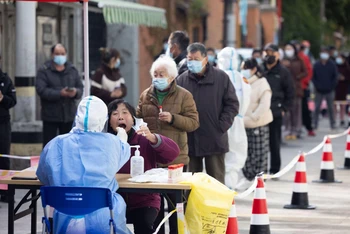 Nhân viên y tế lấy mẫu xét nghiệm Covid-19 cho người dân tại Thượng Hải, Trung Quốc, ngày 1/4/2022. (Ảnh: THX/TTXVN)