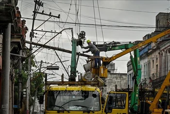 Công nhân sửa chữa đường dây điện sau bão Ian tại El Cerro, Cuba ngày 29/9/2022. Ảnh: AFP/TTXVN