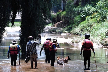 Lực lượng cứu hộ tìm kiếm những người mất tích trên sông Jukskei ở Johannesburg. (Ảnh: AP)