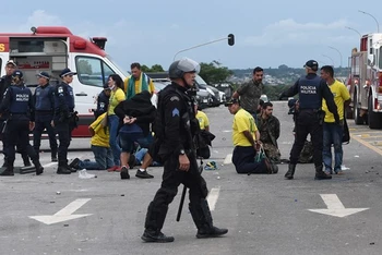 Lực lượng an ninh Brazil bắt giữ các đối tượng biểu tình đột nhập vào Dinh Tổng thống tại Brasilia, ngày 8/1/2023. (Ảnh: AFP/TTXVN)