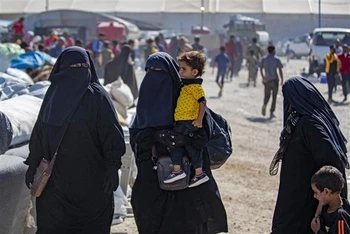 Phụ nữ và trẻ em chuẩn bị rời khỏi trại al-Hol, nơi tạm giữ thân nhân của các đối tượng bị tình nghi là thành viên IS, ở Hasakeh (Syria), ngày 14/8/2022. (Ảnh: AFP/TTXVN)