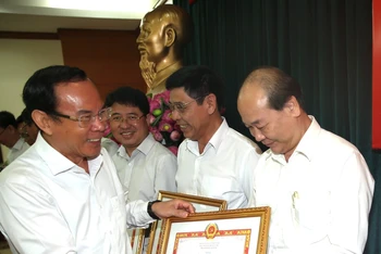 Đồng chí Nguyễn Văn Nên trao bằng khen cho các tập thể. (Ảnh: LONG HỒ)