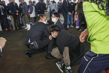 Một người đàn ông, được cho là nghi phạm ném bom khói về phía Thủ tướng Nhật Bản Fumio Kishida, bị cảnh sát khống chế tại cảng cá Saikazaki ở Wakayama, tỉnh Wakayama, tây nam Nhật Bản, ngày 15/4/2023. (Ảnh: Kyodo/Reuters)