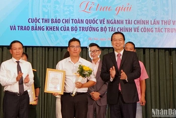 Thứ trưởng Tài chính Nguyễn Đức Chi và Phó Chủ tịch Thường trực Hội Nhà báo Việt Nam Nguyễn Đức Lợi trao giải A cho đại diện nhóm tác giả của Báo Nhân Dân. (Ảnh: TRUNG HƯNG)