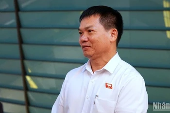 Đại biểu Dương Khắc Mai (Đoàn đại biểu Quốc hội tỉnh Đắc Nông) trao đổi bên hành lang Quốc hội. (Ảnh: TRUNG HƯNG)