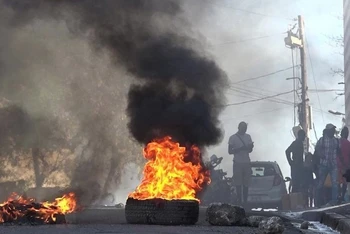Lốp xe bốc cháy gần Nhà tù quốc gia ở Port-au-Prince, Haiti, sau khi hàng nghìn tù nhân vượt ngục ngày 3/3. (Ảnh: AFP/TTXVN)