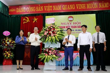 Bộ trưởng Khoa học và Công nghệ Huỳnh Thành Đạt (thứ 2 từ trái sang) tặng hoa chúc mừng cán bộ và nhân dân thôn Ngô Xá, xã Long Châu, huyện Yên Phong, tỉnh Bắc Ninh.