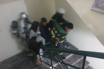 Cảnh sát phòng cháy, chữa cháy cõng cụ già thoát khỏi vụ hỏa hoạn theo cầu thang bộ. (Ảnh: Công an cung cấp)