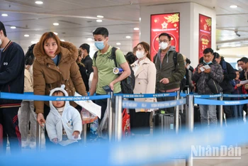 Hành khách xếp hàng làm thủ tục tại Cảng hàng không quốc tế Nội Bài. (Ảnh: Thành Đạt)