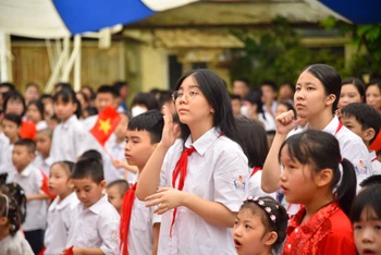 Học sinh trường Phổ thông cơ sở Xã Đàn (Hà Nội) hát quốc ca bằng tay. (Ảnh: NHẬT QUANG)