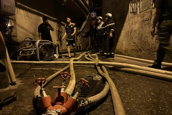 Cảnh sát phòng cháy chữa cháy dẫn nước vào sâu hiện trường. (Ảnh: CTV Nguyễn Hải)