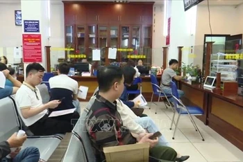 Đầu tháng 4/2024, người dân xếp hàng đăng ký làm thủ tục đất đai rất đông tại Chi nhánh Văn phòng đăng ký đất đai quận Hà Đông (Hà Nội). (Ảnh: TTXVN)