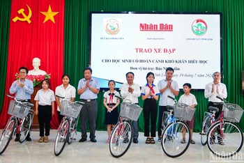 Đồng chí Đinh Như Hoan, Phó Tổng Biên tập Báo Nhân Dân trao tặng xe đạp cho học sinh có hoàn cảnh khó khăn hiếu học tại huyện Vĩnh Linh. (Ảnh: THÀNH ĐẠT)