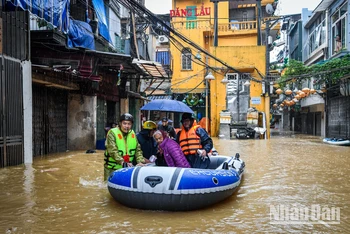 [Ảnh] Phố xá ngập sâu, người dân ven sông Hồng lên thuyền di dời