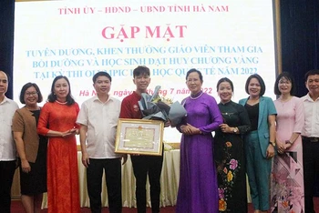 Các đồng chí Thường trực Tỉnh ủy trao Bằng khen, tặng hoa và quà chúc mừng em Trần Đức Minh.