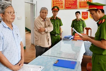 Phòng Cảnh sát kinh tế tống đạt các quyết định khởi tố và Lệnh bắt bị can để tạm giam đối với Thái Minh Hoàng (bên trái hình) và Nguyễn Đình Tấn (ở giữa).