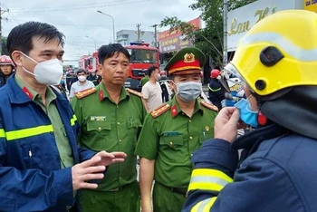 Đại tá Trịnh Ngọc Quyên, Giám đốc Công an tỉnh Bình Dương (bìa trái) đến hiện trường chỉ đạo công tác chữa cháy và cứu nạn cứu hộ vụ cháy cơ sở karaoke An Phú.