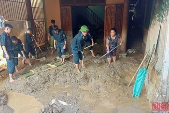 Các lực lượng giúp dân khắc phục lũ lụt ở Khối 1 thị trấn Mường Xén.