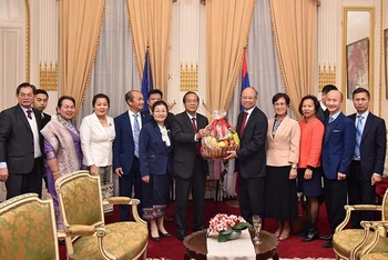 Đại sứ Việt Nam tại Pháp Đinh Toàn Thắng tặng hoa chúc mừng Quốc khánh nước Cộng hòa dân chủ nhân dân Lào. (Ảnh: MINH DUY)