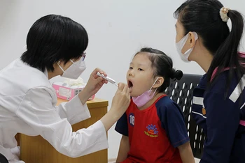 Các trẻ em được bác sĩ khám, tầm soát sức khỏe.