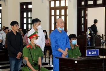 Bị cáo Phạm Văn Nam (đứng trước) và ba bị cáo: Trần Quốc Phong, Nguyễn Thiện Khiêm và Võ Lam Trường (đứng hàng sau) tại phiên tòa.