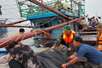 Bộ đội Biên phòng giúp ngư dân trên tàu cá bị chìm đưa ngư lưới cụ vào bờ.