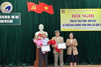 Chủ tịch Hội Văn nghệ dân gian Đà Nẵng Đinh Thị Trang trao giải thưởng năm 2023 cho các tác giả. (Ảnh: ANH ĐÀO)