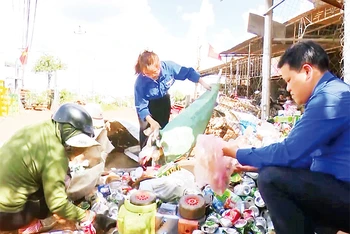 Đoàn viên xã Tân Thành cùng người dân phân loại rác thải tại một điểm "Ngôi nhà 100 đồng".