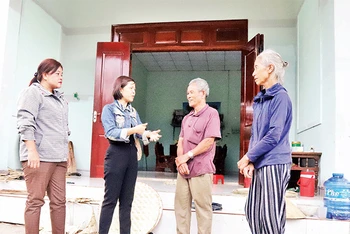 Cán bộ huyện Krông Bông và thị trấn Krông Kmar cùng vợ chồng ông Mai Văn Trung trước ngôi nhà mới có một phần kinh phí từ Quỹ tiết kiệm làm theo lời Bác.