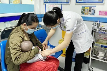 Tiêm vắc-xin cho trẻ em tại Trung tâm Kiểm soát bệnh tật tỉnh Quảng Ninh. (Ảnh NGUYỄN HUẾ)