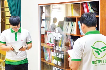 Công nhân lao động sử dụng phòng đọc sách tại điểm sinh hoạt văn hóa công nhân ở Công ty Cổ phần Nicotex, quận Long Biên. (Ảnh ĐỖ PHƯỢNG)