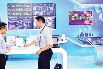 Nhân viên Tập đoàn Bưu chính Viễn thông Việt Nam (VNPT) giới thiệu hệ sinh thái chuyển đổi số VNPT cho khách hàng. (Ảnh NGỌC MINH)