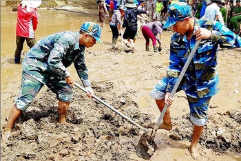 Cán bộ, chiến sĩ Trạm Ra-đa 37, Trung đoàn 293, Sư đoàn 361, Quân chủng Phòng không-Không quân giúp Trường tiểu học Nà Ớt, xã Nà Ớt, huyện Mai Sơn, tỉnh Sơn La khắc phục hậu quả mưa lũ.