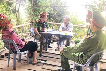 Cán bộ, chiến sĩ Công an xã Túc Đán, huyện Trạm Tấu trao đổi thông tin bảo đảm an ninh - trật tự với người dân bản Pa Khoang.