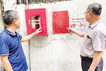 Người dân Tổ 5, phường Thạch Bàn (quận Long Biên) trao đổi về cách sử dụng bình chữa cháy công cộng tự trang bị.