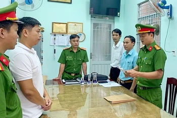 Lực lượng chức năng tỉnh Bình Phước tống đạt các quyết định khởi tố bị can, bắt tạm giam các đối tượng thành lập công ty bán khống hóa đơn. (Ảnh HOÀNG PHI)